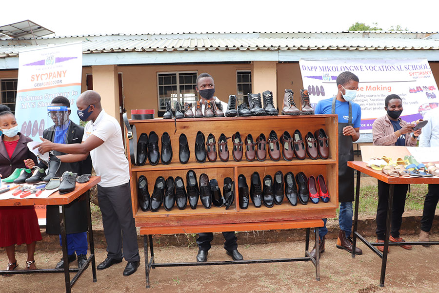 Shoe making students display products made during their training